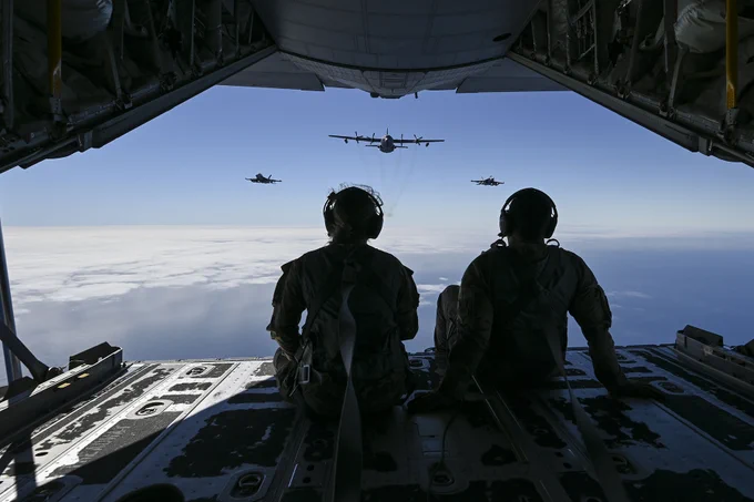 Air Force 2nd Lt. Ella Furlong, left, and Tech. Sgt. Austin Temple watch two Navy EA-18G Growler aircraft fly in formation with an EC-130H Compass Call aircraft during Gray Flag 24 off the coast of California.