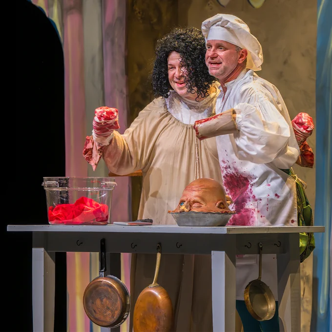 Two men cooking with fake blood and a human head.