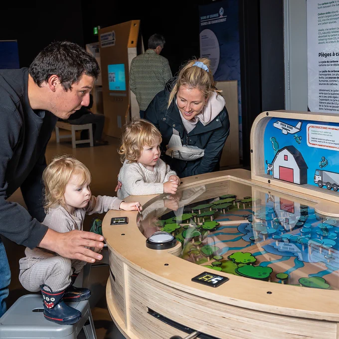 A family engages with an interactive display at the Telus World of Science’s Our Climate Quest exhibition