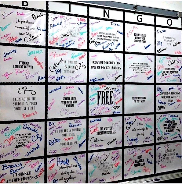 Bulletin board has been divided into a grid of 25 squares, each with a way of supporting fellow teachers. Teachers have signed their names where they've completed a given act of kindness.