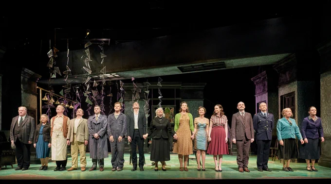 Curtain call for The House, a line of 15 actors about to take their bows on stage at the end of a performance