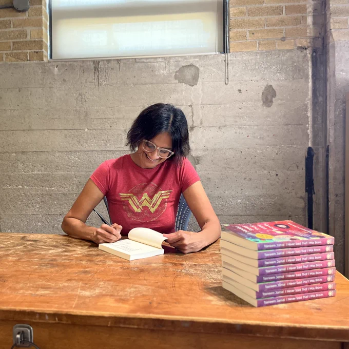 Tasneem Jamal signing copies of I Never Said That I Was Brave.