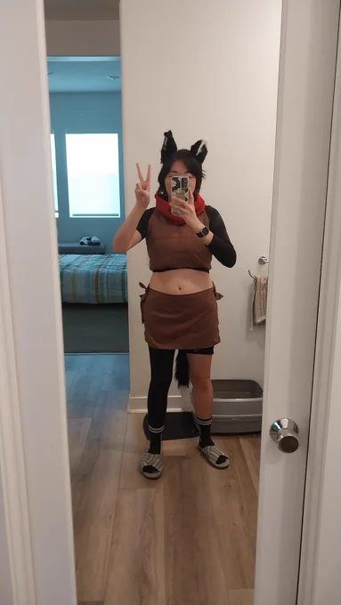 Me dressed up as izutsumi from dungeon meshi, posing in the mirror with a peace sign