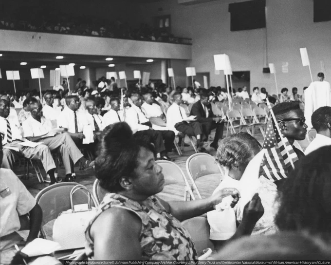 A black-and-white photograph of Fannie Lou Hamer during the Miss Mississippi Freedom Democratic Party Convention (1964). She is seated with a mini paper fan in her hand.