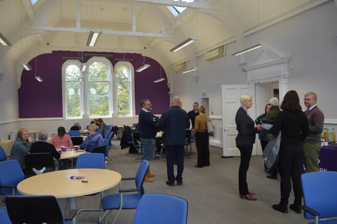 A group of people chatting in a conference room at the launch event