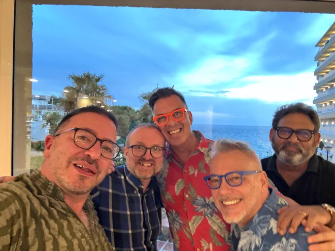 Photo of Dr Simone Bacchini, Dr Peter Simcock, Dr Walter Wittich, Norman Bois and Akhil Paul. All are stood, smiling in front of a window, the view from which is the sea.