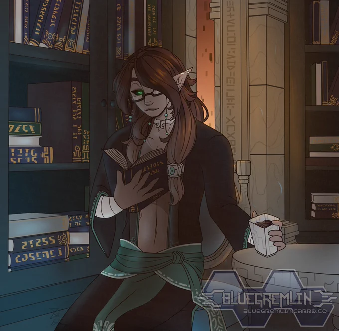 Picture shows a man holding a cup of tea on one hand, and a book in the other. He is sitting in a chair, surrounded by bookshelves. 