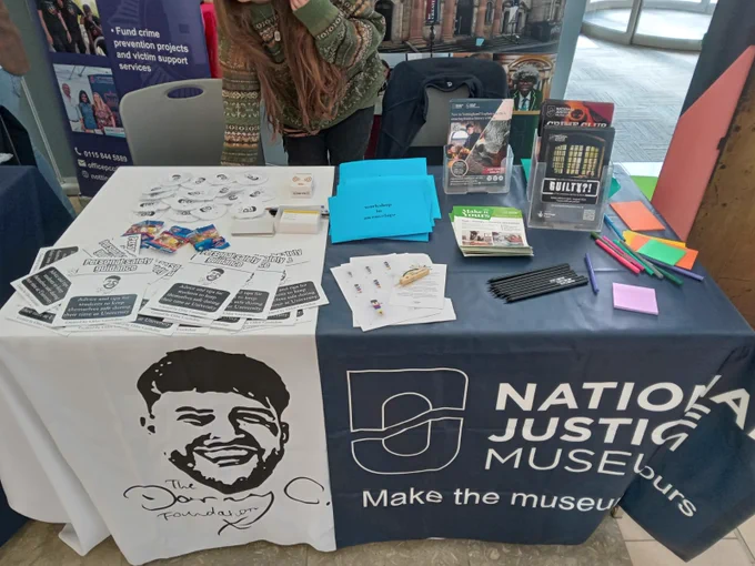 Table with leaflets, drinks covers, pencils ad workshops in envelopes.