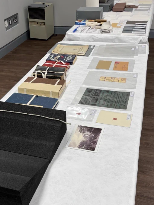 A selection of 20th century special collections examples such as books, pamphlets, posters, arranged on a display table.
