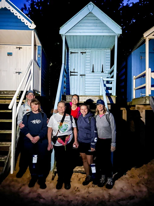 The OPM team on their charity walk standing in front of a beach hut