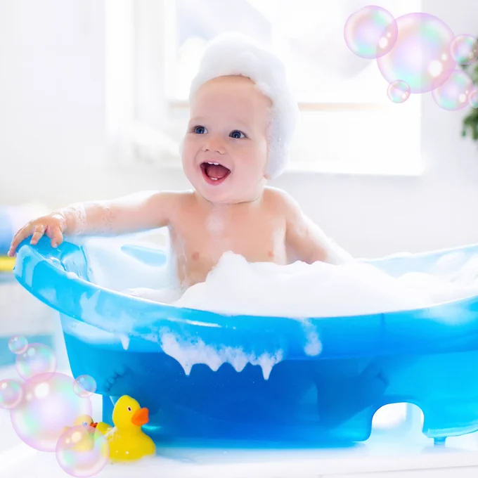 Baby taking a bubble bath with rubber ducks