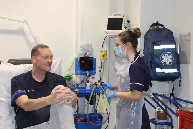 A research nurse with a patient