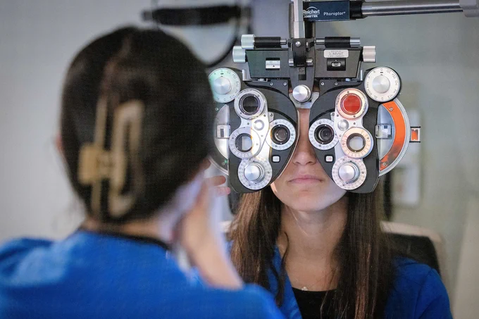 Two SUNY Optometry students  show how to use a phoropter