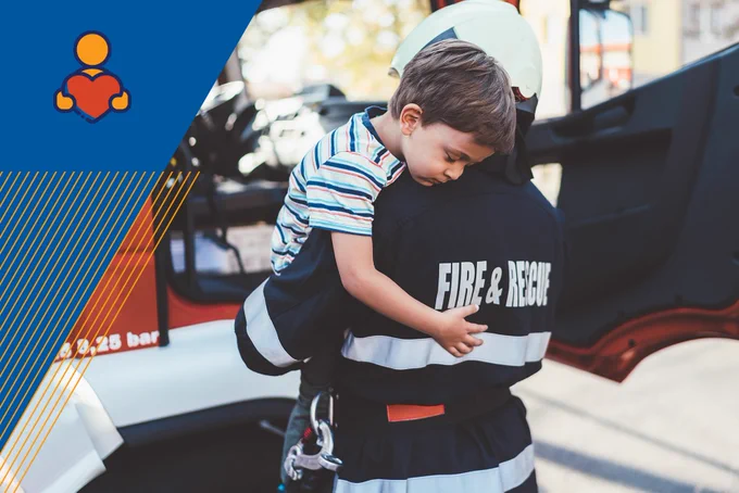 Image Description: A fireman carrying a small boy in his arms.