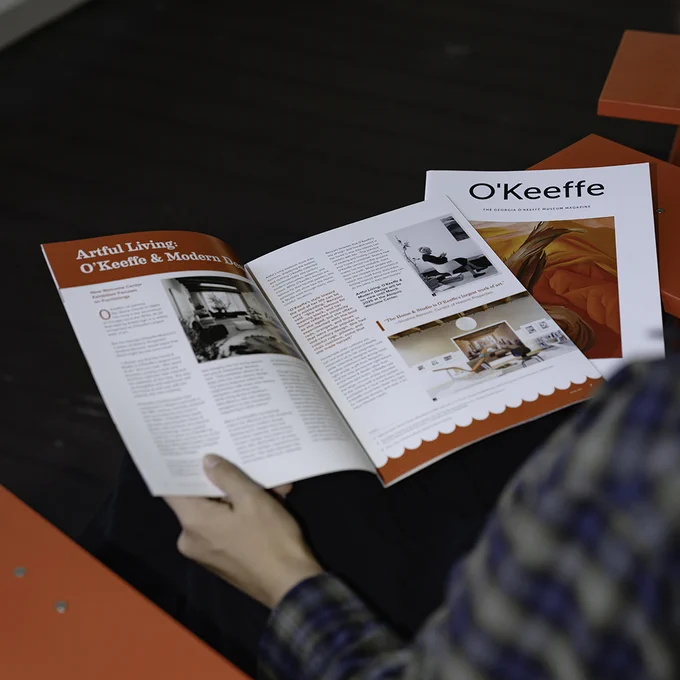 Photograph of a magazine open on a person’s lap as they read it. 
