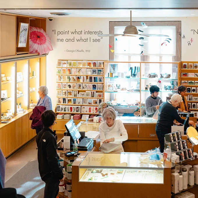 Photograph of several people shopping in a small museum store.