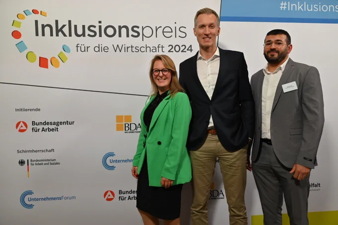 Das Foto zeigt Daniel Terzenbach, Vorstand Regionen, zusammen mit zwei Mitarbeitenden der Bundesagentur für Arbeit beim Inklusionspreis für die Wirtschaft 2024.