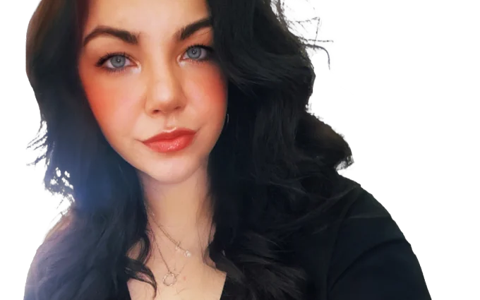 Portrait of a person with long, dark hair and blue eyes, wearing a black top.