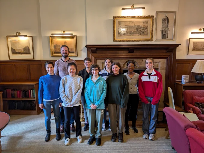 Group photo in front of a fireplace
