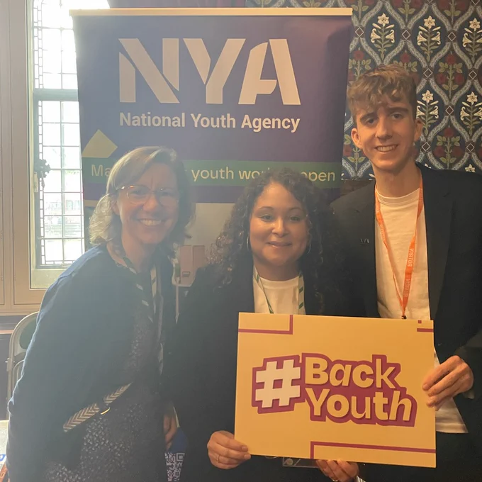 A photo of NYA Policy intern and youth project assessor Harrison Humby with MP Lauren Sullivan and MP Natasha Irons. They hold up a sign with the hashtag #BackYouth
