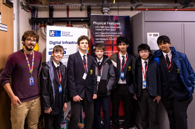 6 school boys stood with a STFC staff member at a scientific computing schools day.