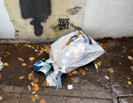 Photo of a white First Mile bag lying on the pavement