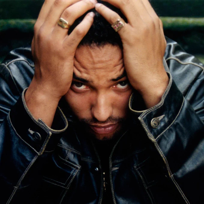 Close up of man with his hands around his head, eyes facing the camera.