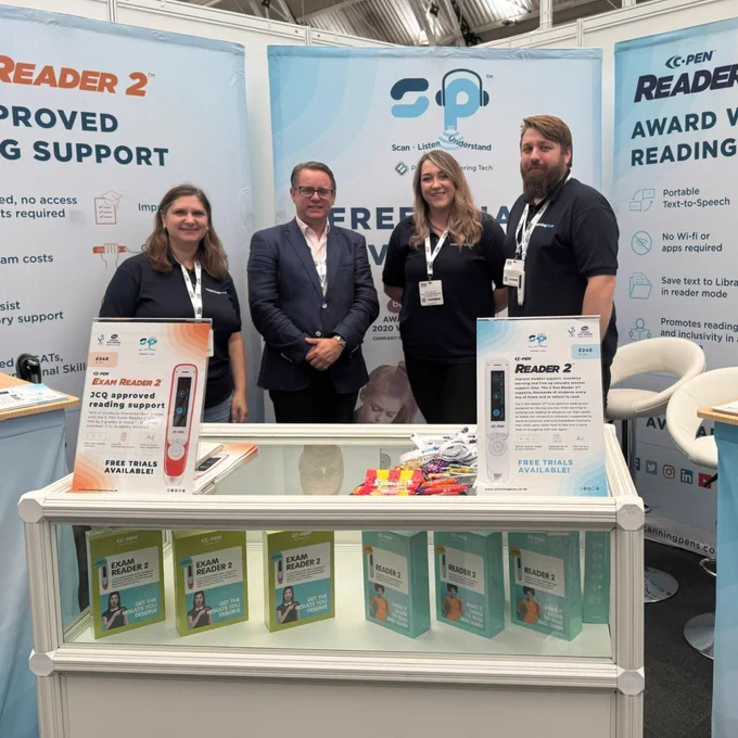Scanning pens team members at there stand at the Tes SEND show promoting the "C-Pen READER 2" with promotional materials and electronic devices displayed on the counter.
