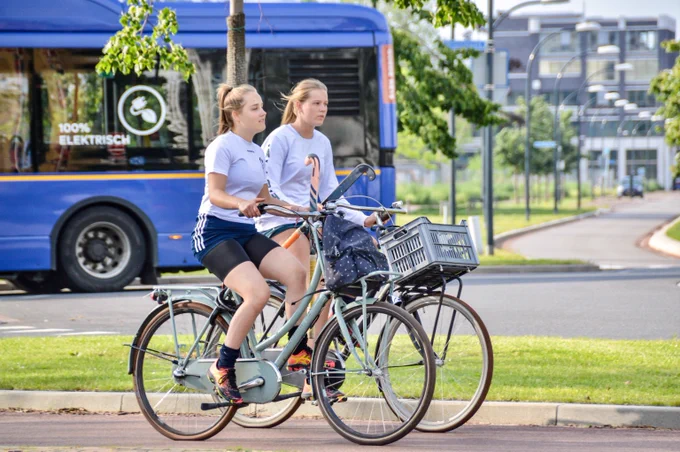 Teens with hockey equipment cycling in Maastricht