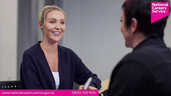 A woman sat talking to a careers adviser. Top right is the National Careers Service logo and bottom left reads: "www.nationalcareers.service.gov.uk / 0800 100 900". 
