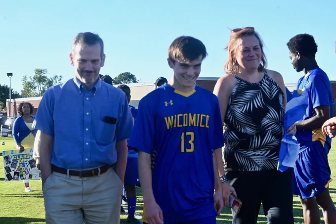 Image of Wi-Hi senior boys soccer player being celebrated by teammates and family