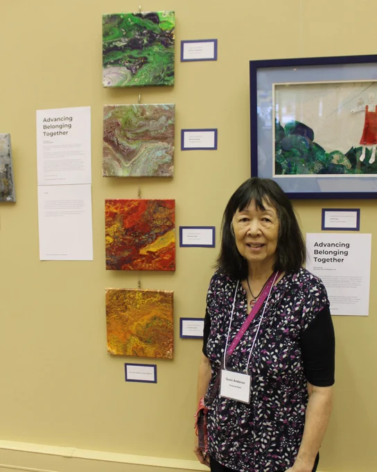 A photo of Gwen Andersen, ForHealth Consulting healthcare data analyst and a featured artist at the “Advancing Belonging Together" exhibit, with her art