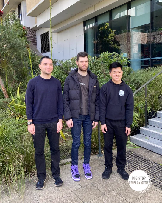 3 guys outside a building dressed in black.