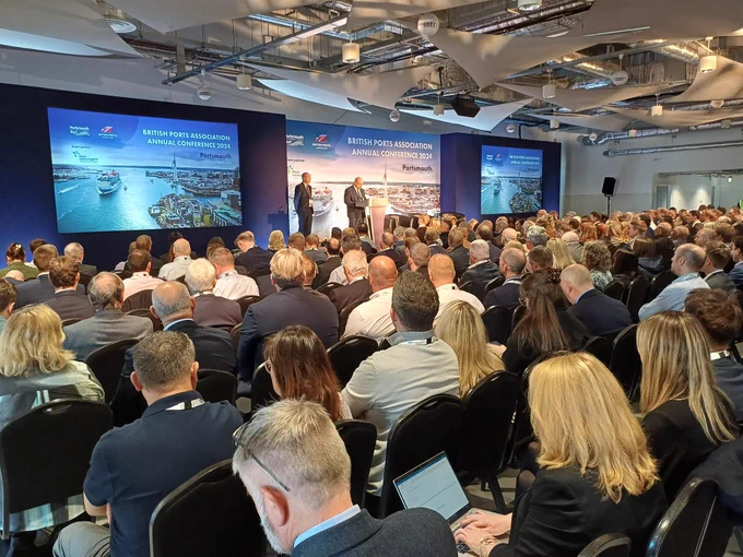 A room full of delegates listens to a welcome speech from Cllr Steve Pitt, leader of Portsmouth City Council