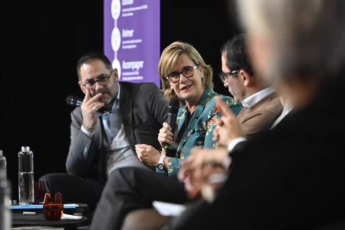 Marie-Agnès Poussier-Winsback prend la parole sur scène aux côtés de Jérôme Saddier.