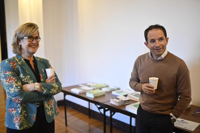 Marie-Agnès Poussier-Winsback et Benoît Hamon discutent avec les organisateurs avant leur intervention sur scène. Ils tiennent tous les deux un gobelet dans les mains.