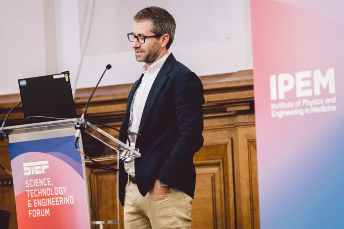 Paul Doolan stands by a branded Science Technology and Engineering Forum lectern 
