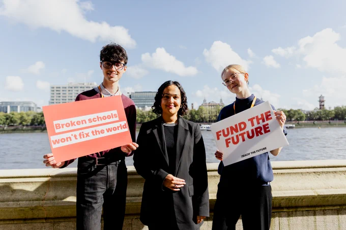 Nadia Whittome MP standing with two TTF students who are holding signs saying "Broken schools won't fix the world" and "Fund the Future"