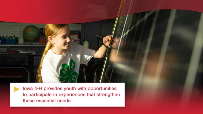 A person wearing an Iowa 4-H t-shirt is drawing on a whiteboard in a sunlit room, accompanied by text stating, "Iowa 4-H provides youth with opportunities to participate in experiences that strengthen these essential needs.