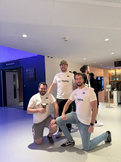 Three average white men in identical football shirts cosplaying as a team