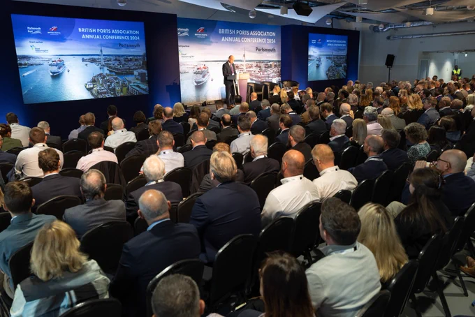 A room full of delegates listen to the opening remarks of the conference