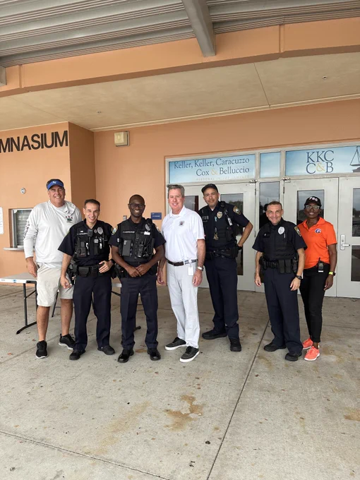 Group of people pose outside school used as evacuation shelter ahead of Hurricane Milton