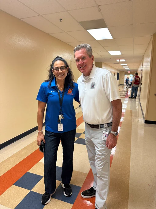 Two people pose in school hallway used as evacuation shelter ahead of Hurricane Milton