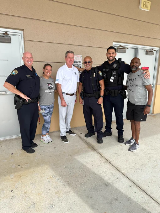 Group of people pose outside school used as evacuation shelter ahead of Hurricane Milton