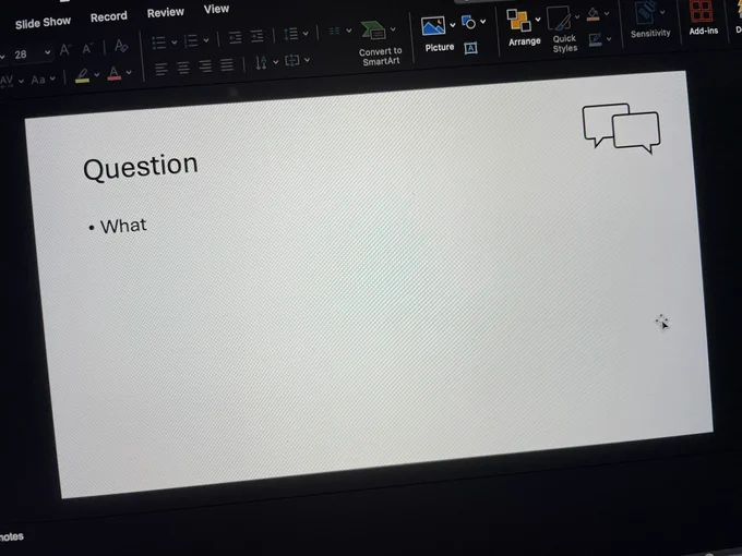 Photo of a laptop screen with a PowerPoint slide on it with a title “Question” and the main text is simply “What”