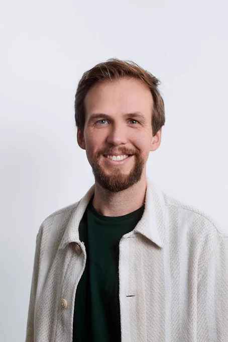My new profile pic, which is me smiling at the camera, wearing a white shirt over a green one