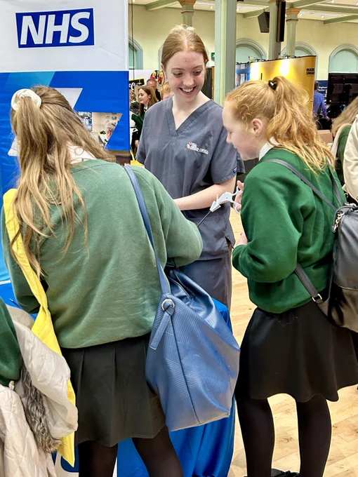 Member of staff speaking to two students.