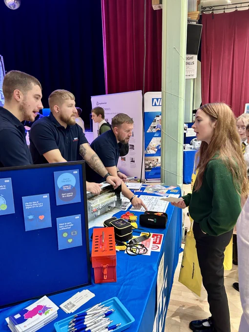 3 members of staff speaking to a student.