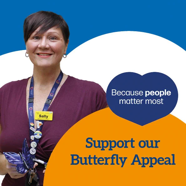 Picture of Sally Sloane holding glass butterflies with text ‘Because people matter most. Support our Butterfly Appeal’