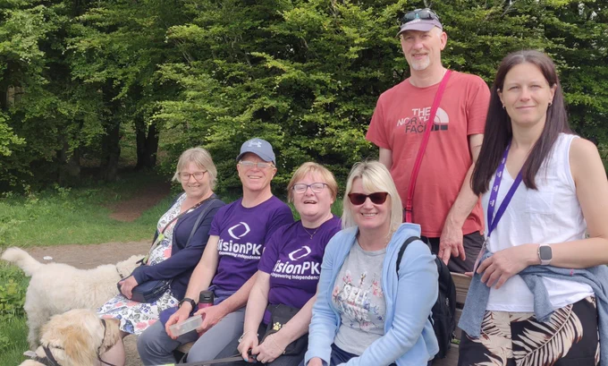 Group photo of 4 women and 2 men on a walk with 2 guide dogs